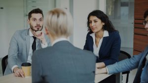 Four colleagues engaged in a serious workplace conversation.